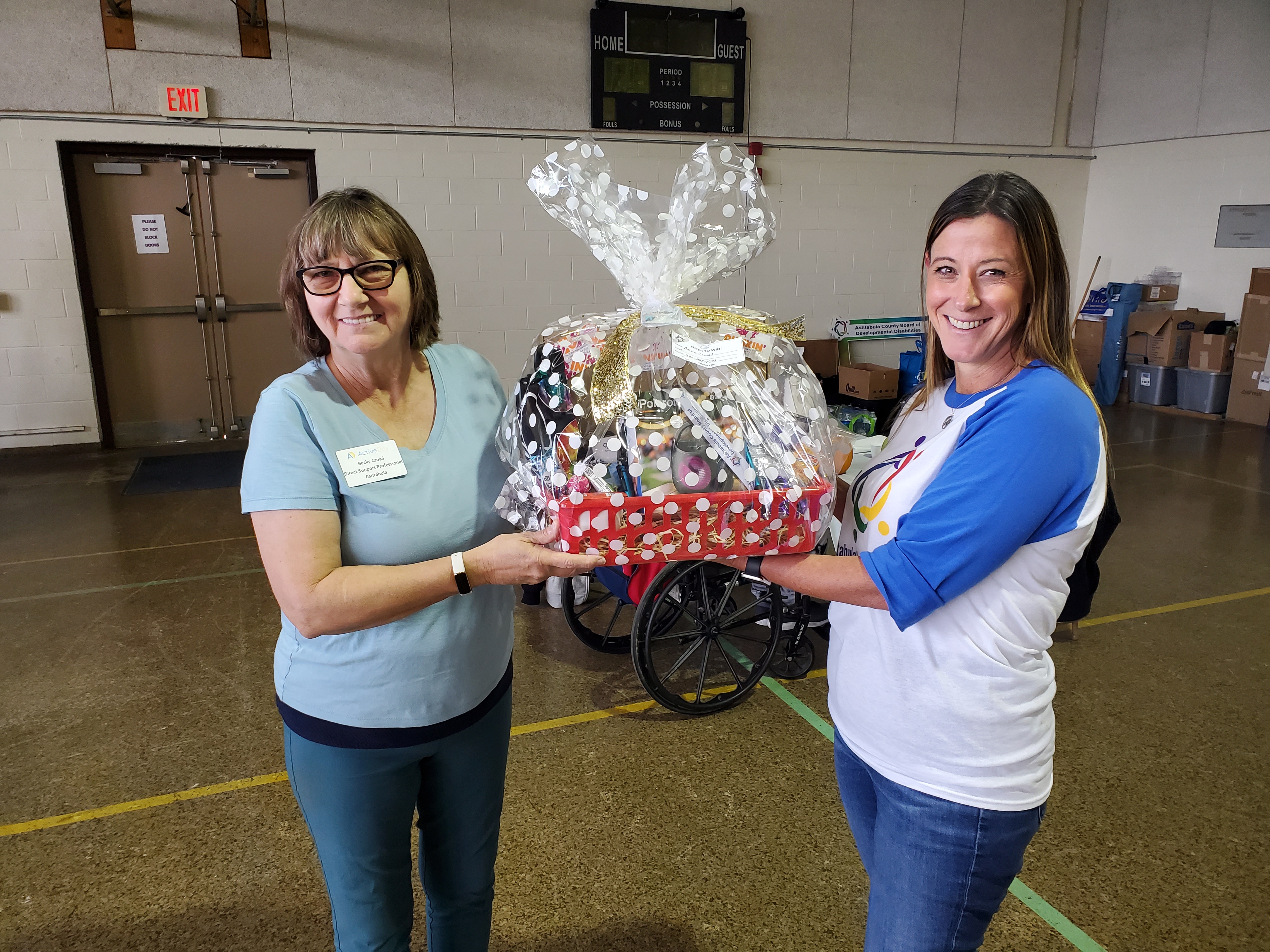 two staff membes holding gift basquet